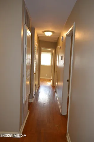 a view of a hallway with wooden floor