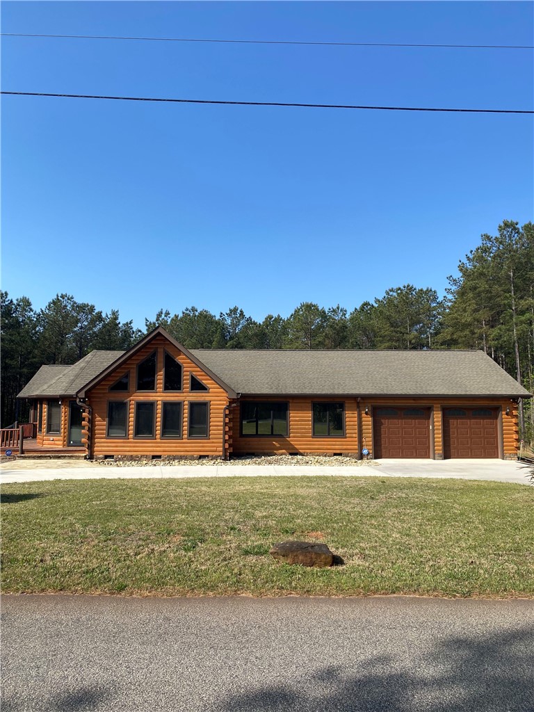 Log exterior siding and a dual-door garage define this rustic mountain retreat.