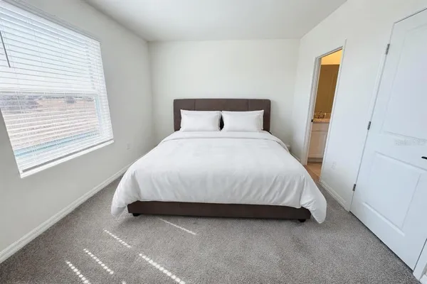 a large bed sitting in a bedroom next to a window