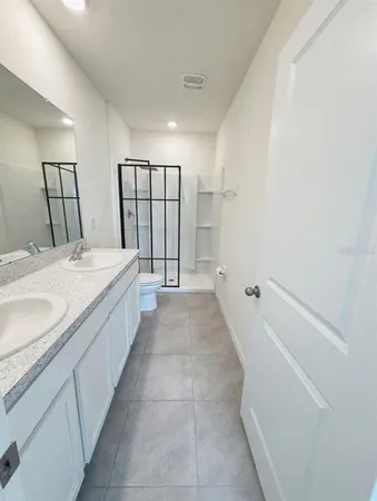 a spacious bathroom with a granite countertop sink a mirror and a bathtub