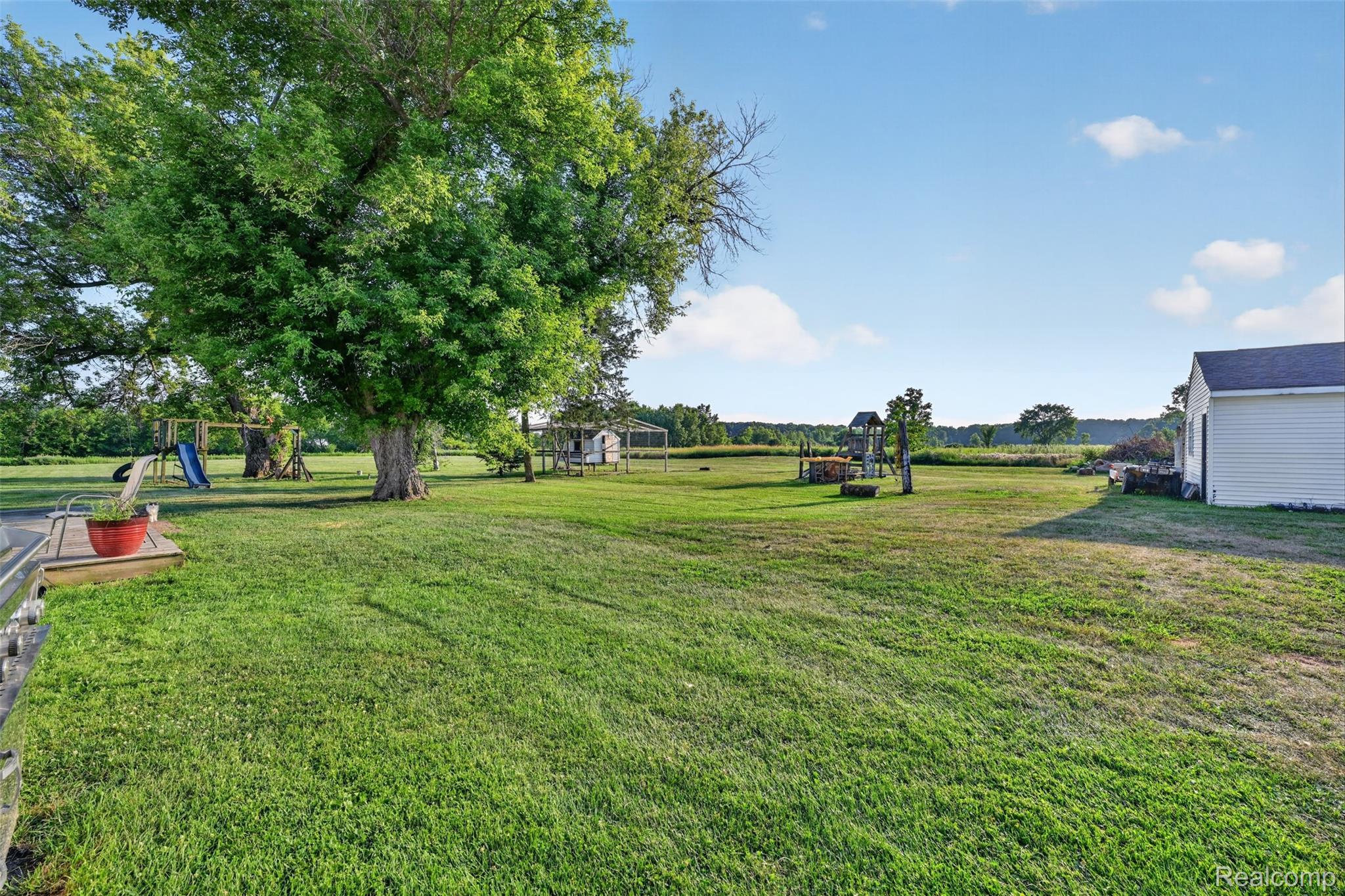 7369 North Webster Road Mount Morris, MI 48458 - Photo 49 of 56 Expansive grassy lawn with mature trees and a white-sided outbuilding