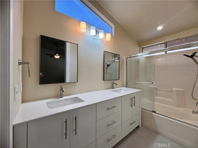 a bathroom with a double vanity sink mirror and shower