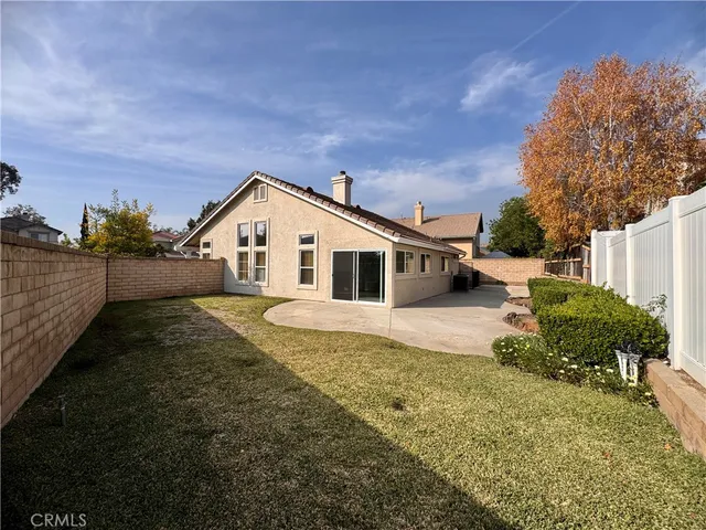 a view of a house with backyard and trees