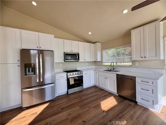 a large kitchen with cabinets stainless steel appliances and window