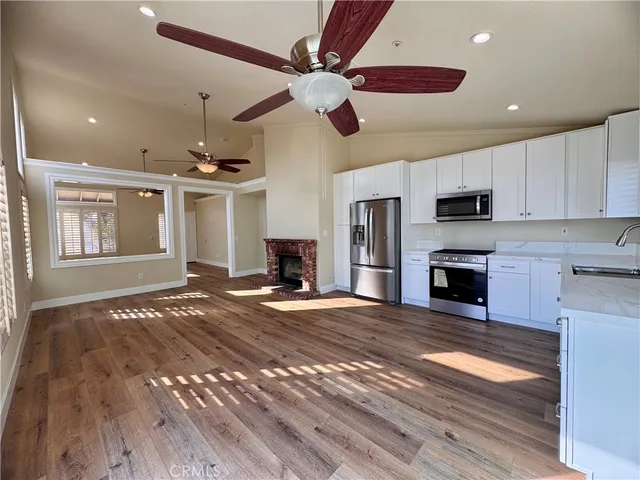 a view of an empty room and kitchen view