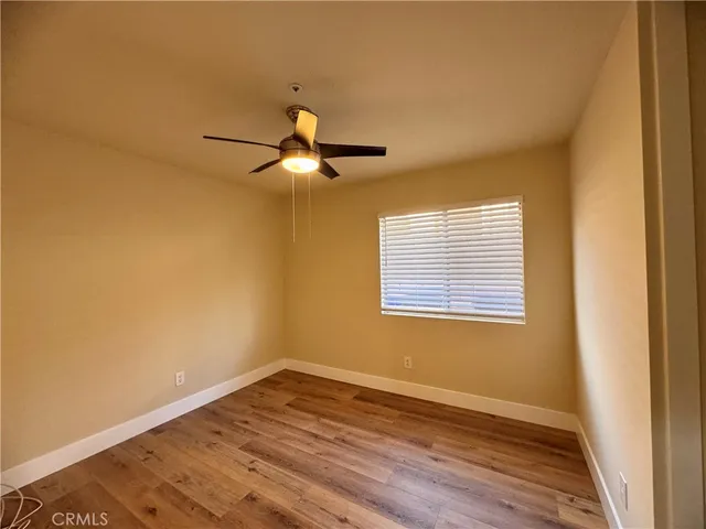 a view of a room with wooden floor and a window