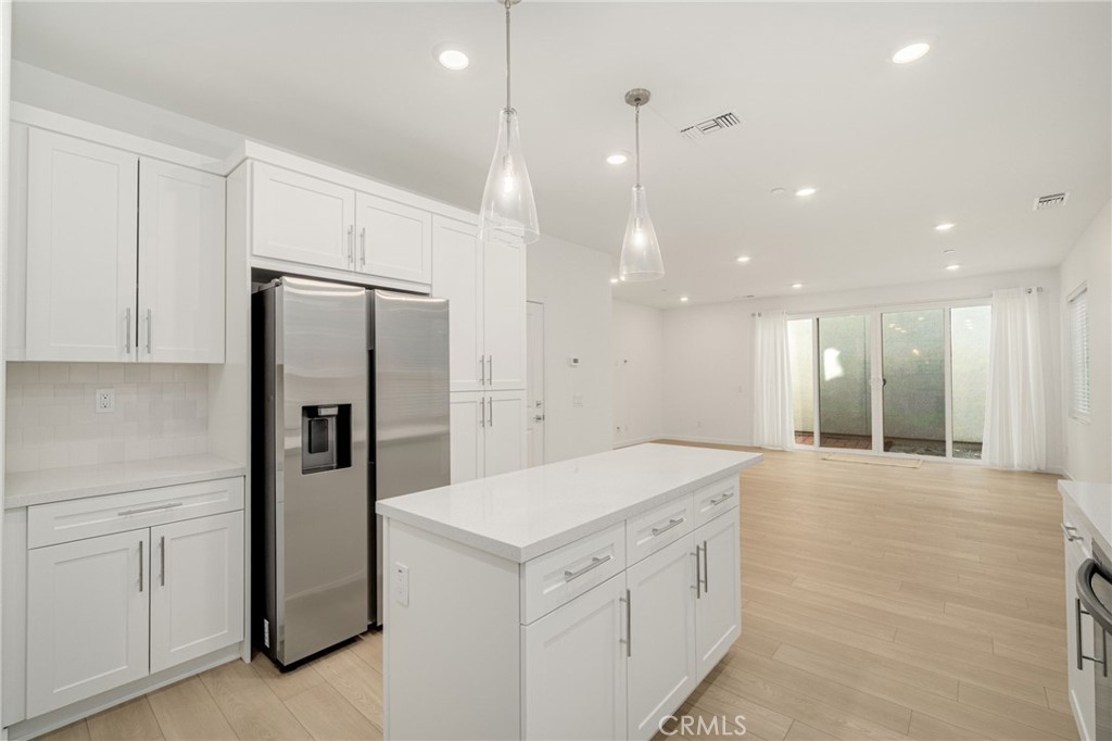 a kitchen with white cabinets and refrigerator