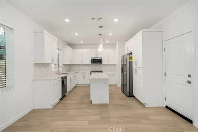 a kitchen with a sink a counter top space stainless steel appliances and cabinets