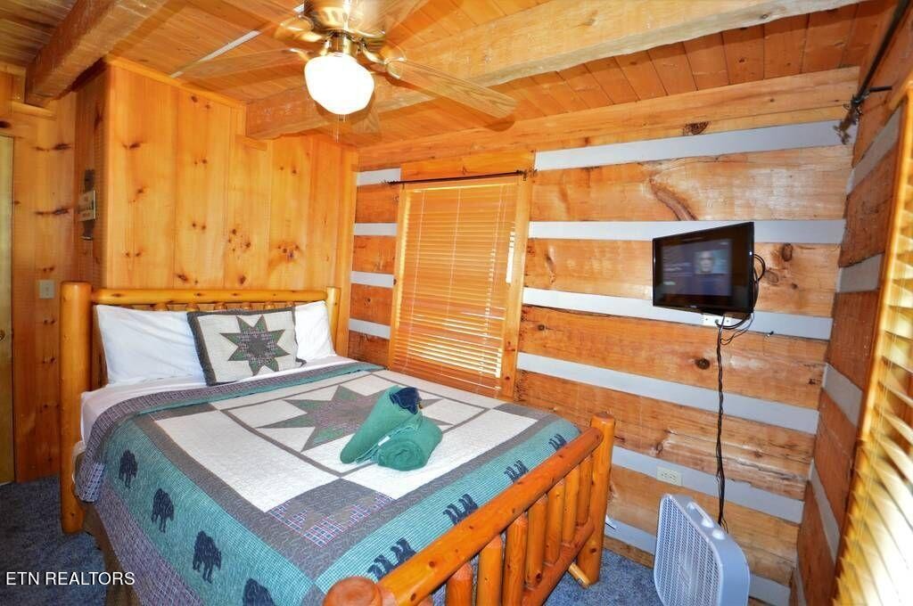 2165 Rising Fawn Way Sevierville, TN 37862 - Photo 11 of 24 a bedroom with a bed and flat tv screen on the dresser