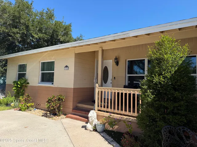 a view of a house with porch and garden