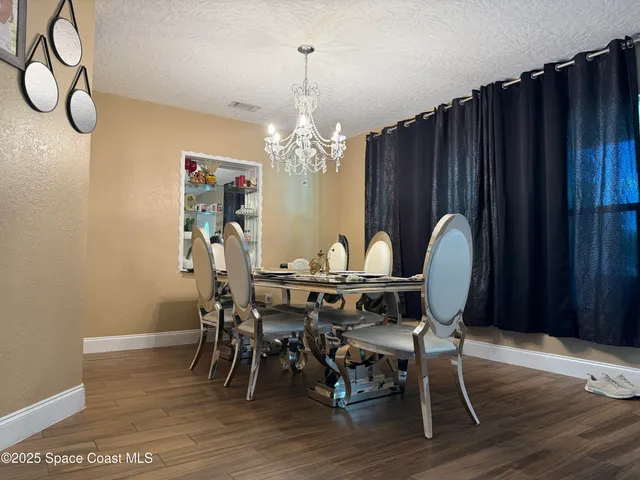 a view of a dining room with furniture wooden floor and chandelier