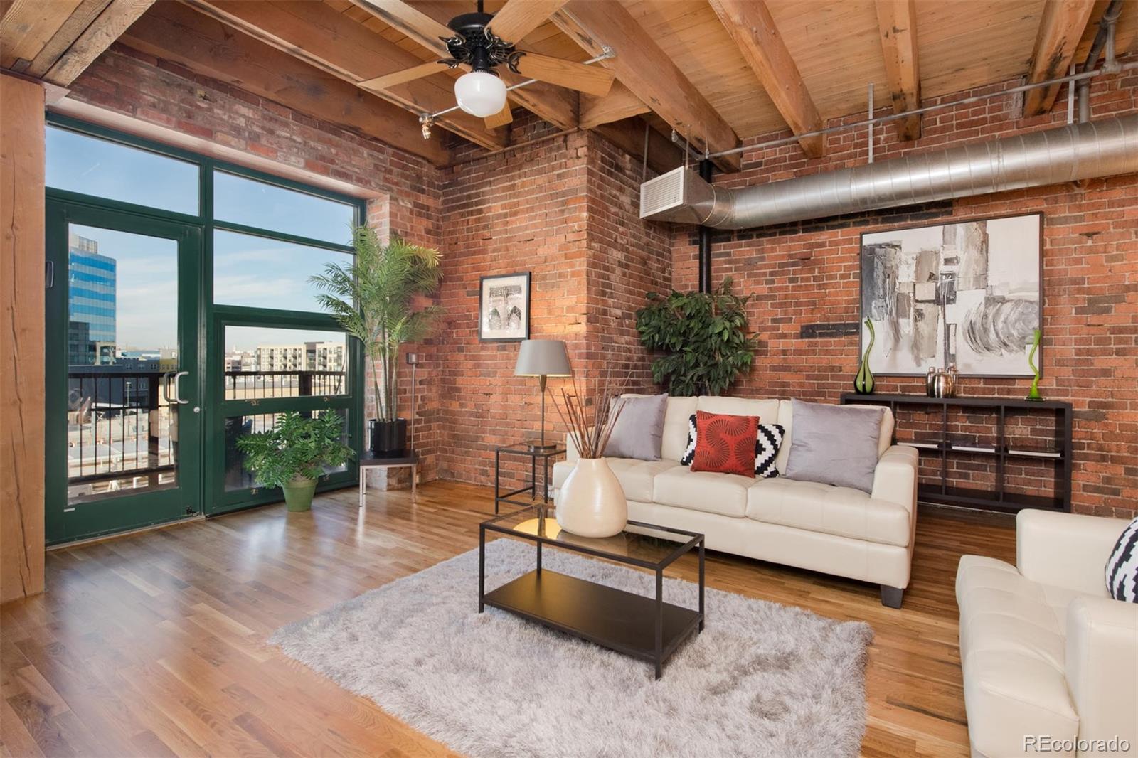 1801 Wynkoop Street, Unit 418 Denver, CO 80202 - Photo 18 of 35 a living room with furniture a ceiling fan and a large window