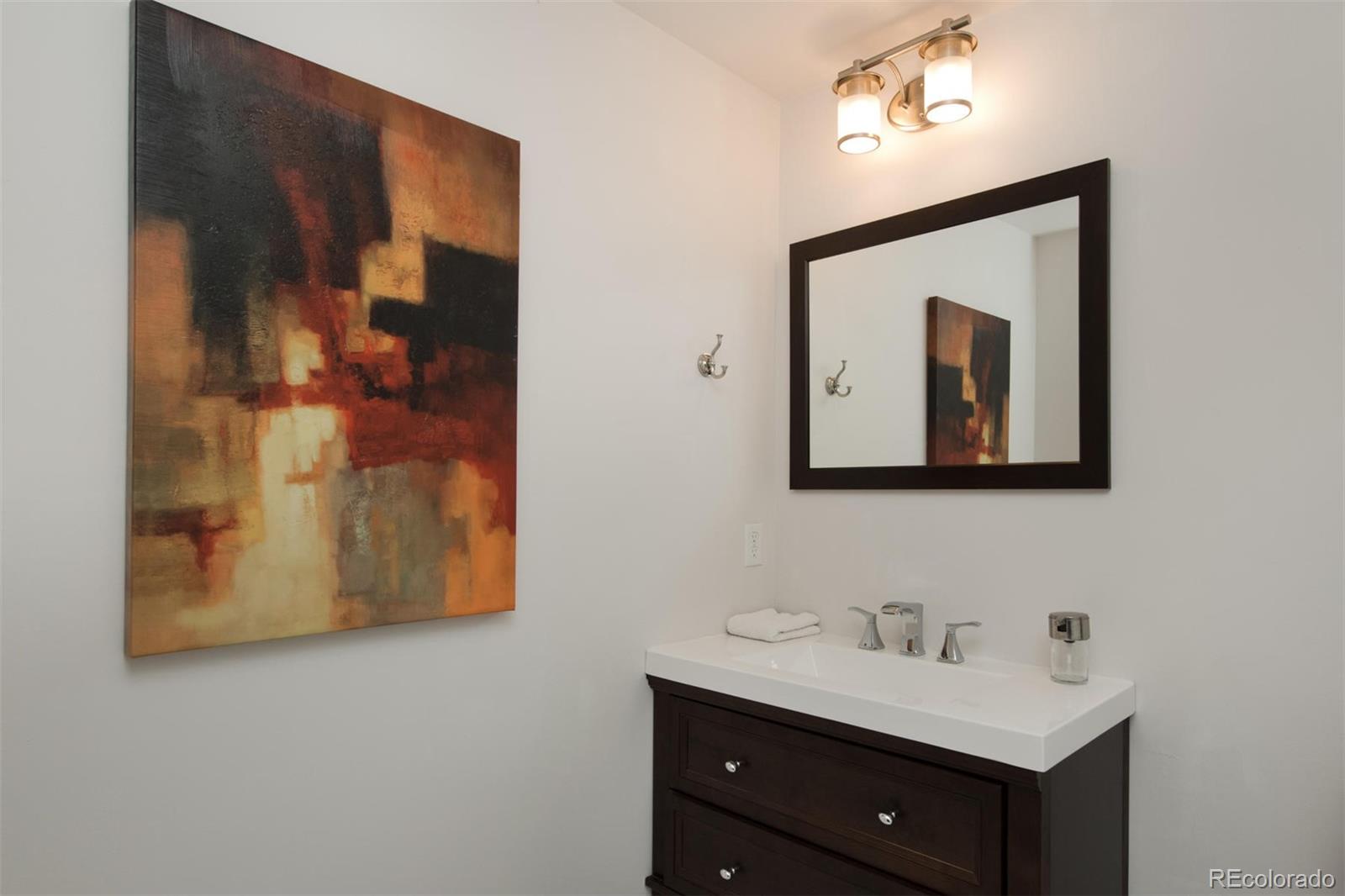 1801 Wynkoop Street, Unit 418 Denver, CO 80202 - Photo 33 of 35 a bathroom with a toilet sink vanity and mirror