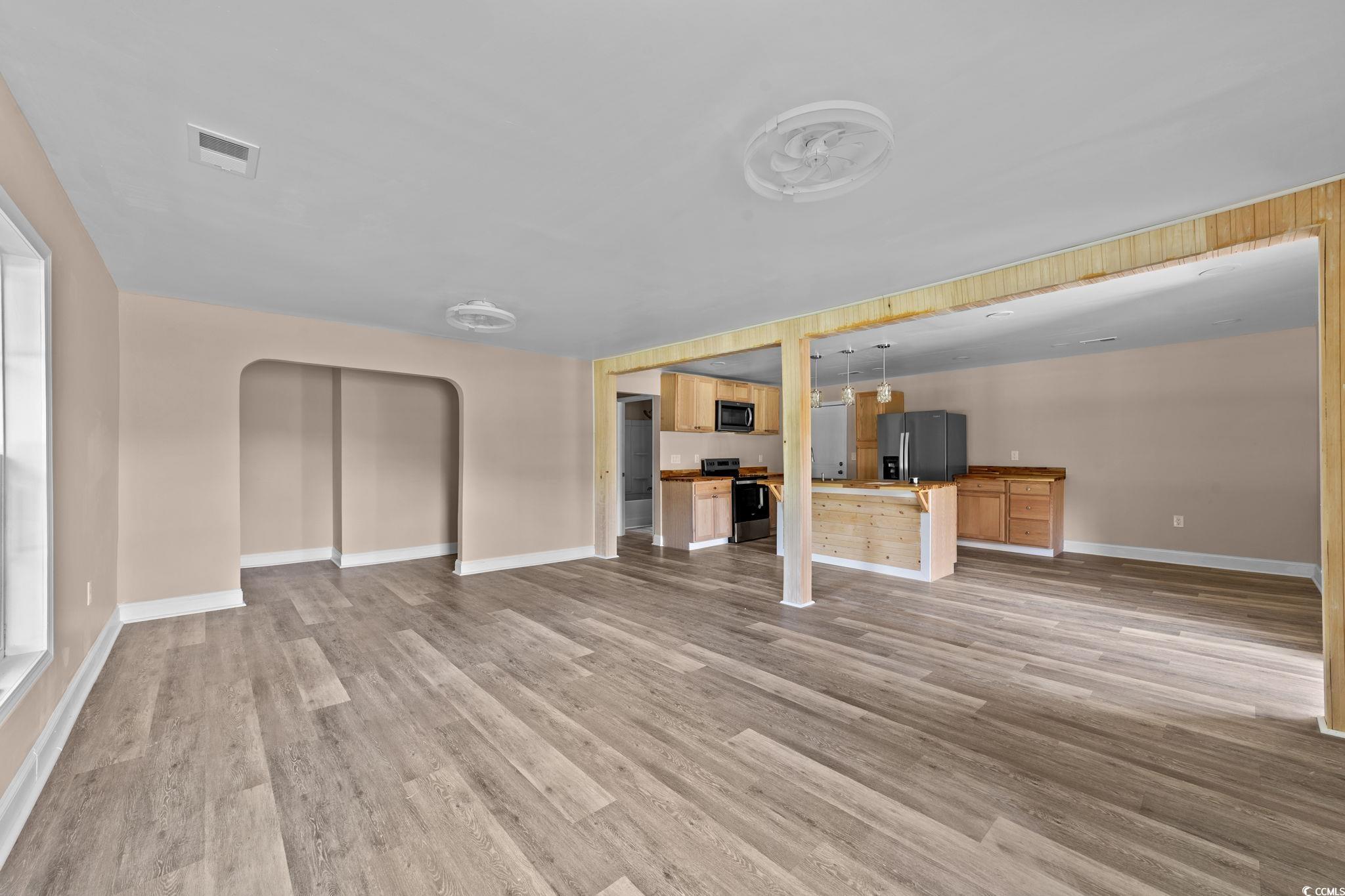 1821 Hawkins Street Georgetown, SC 29440 - Photo 20 of 40 Unfurnished living room featuring arched walkways and light wood-type flooring