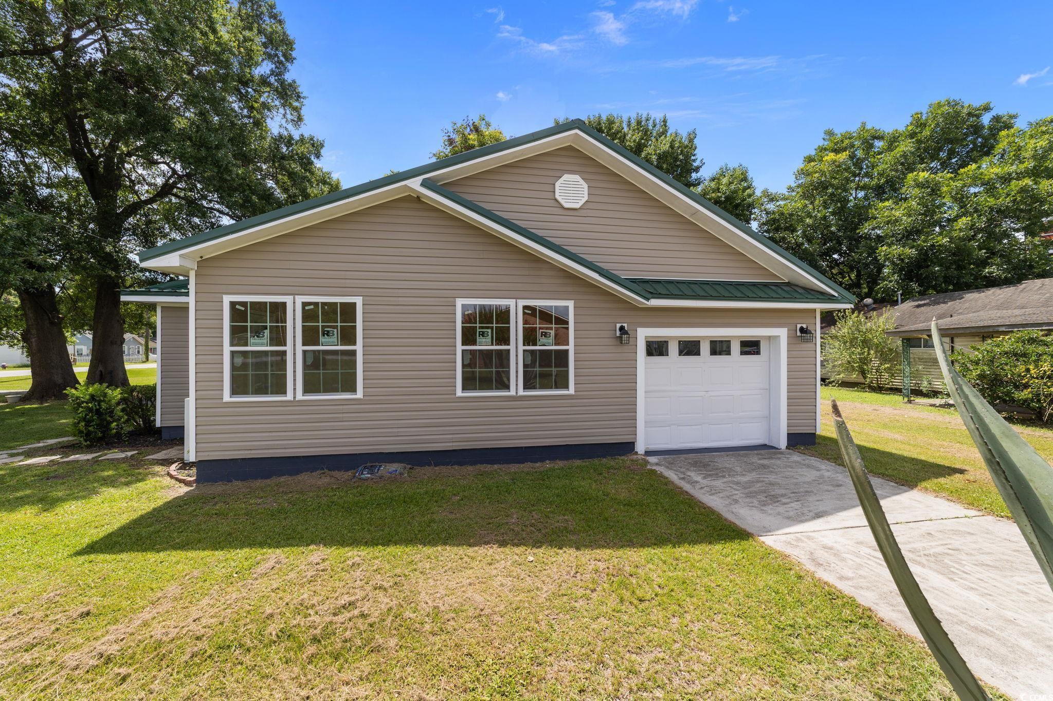 1821 Hawkins Street Georgetown, SC 29440 - Photo 2 of 40 View of front facade with concrete driveway, a front yard, and an attached garage