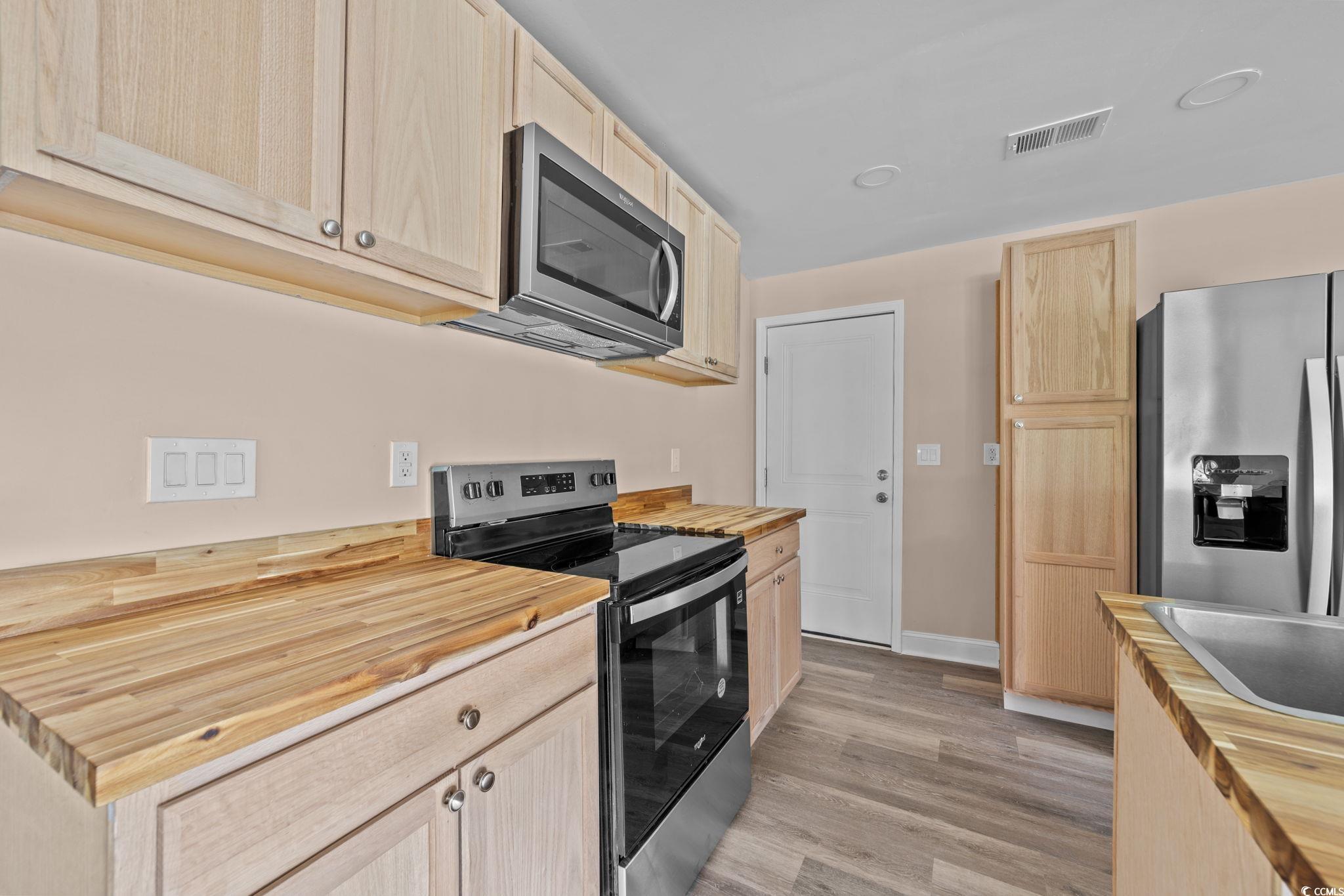 1821 Hawkins Street Georgetown, SC 29440 - Photo 21 of 40 Kitchen with butcher block countertops, light brown cabinetry, stainless steel appliances, and light wood finished floors