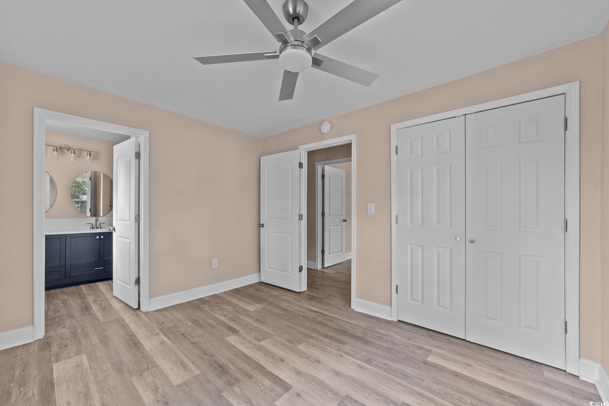 1821 Hawkins Street Georgetown, SC 29440 - Photo 32 of 40 Unfurnished bedroom featuring light wood finished floors, a closet, ensuite bath, and a ceiling fan