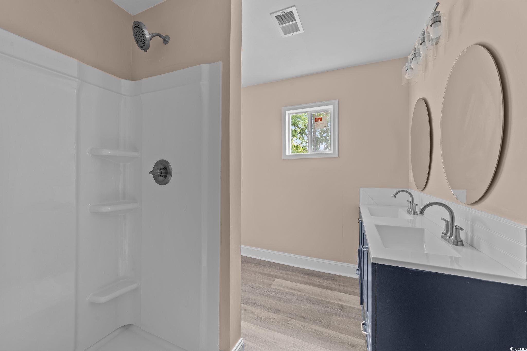 1821 Hawkins Street Georgetown, SC 29440 - Photo 34 of 40 Bathroom with wood finished floors, double vanity, and a shower