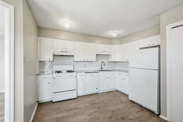 a kitchen with cabinets appliances a sink and a counter top space