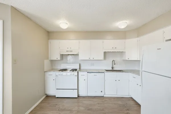 a kitchen with a sink a stove and cabinets
