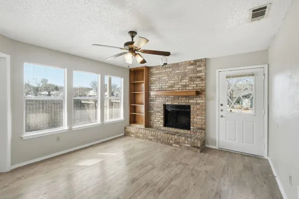 a view of an empty room with window and fire place