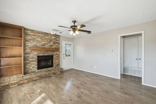 a view of a livingroom with a fireplace and a chandelier fan