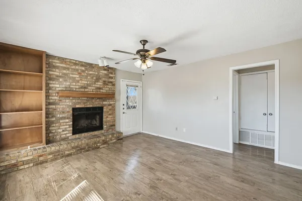 a view of a livingroom with a fireplace and a chandelier fan
