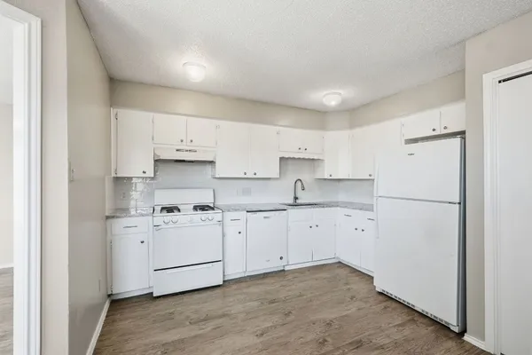 a kitchen with cabinets appliances a sink and a counter top space