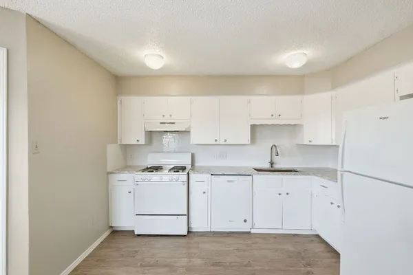 a kitchen with a sink a stove and cabinets