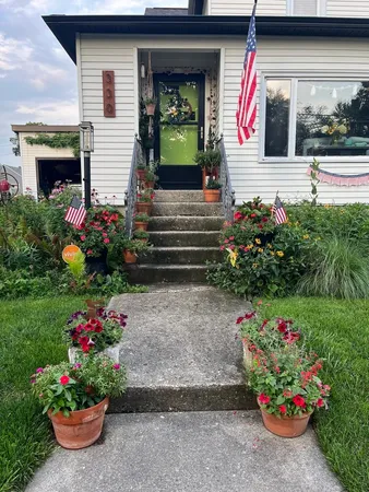 a front view of a house with lots of flowers and flowers