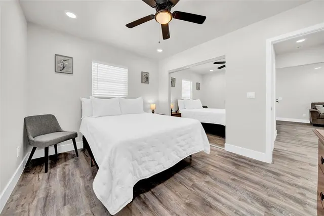 a spacious bedroom with a bed and a chair