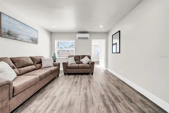 a living room with furniture and a wooden floor