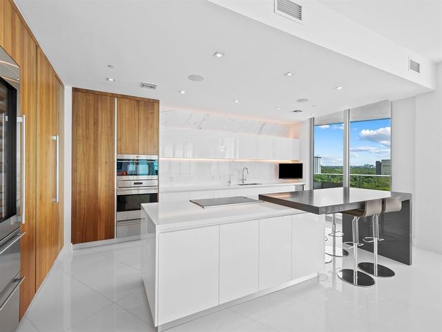a kitchen with a sink a stove and chairs