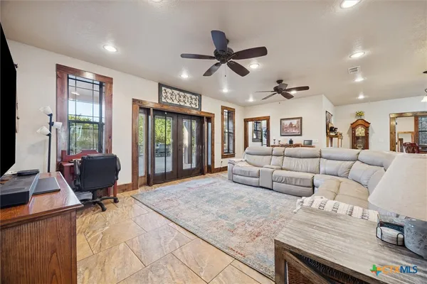 a living room with furniture ceiling fan and a window