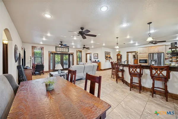 a living room with lots of furniture a rug and a chandelier