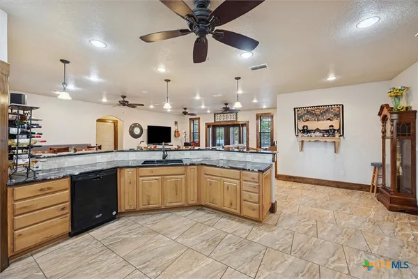 a large kitchen with stainless steel appliances granite countertop a stove and a sink
