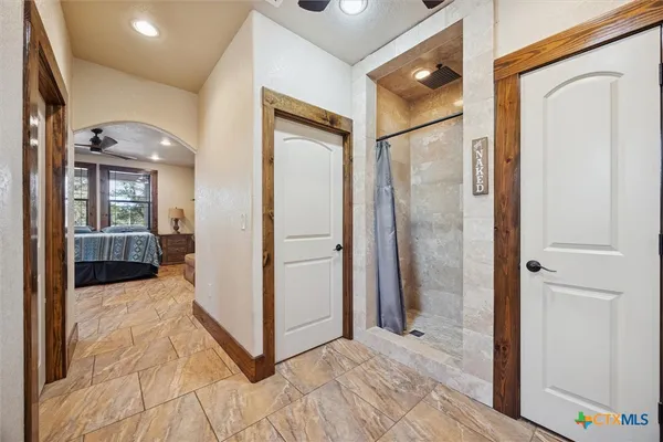 a view of a hallway with bathroom and wooden floor
