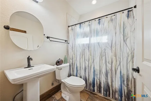 a bathroom with a sink a toilet and a mirror