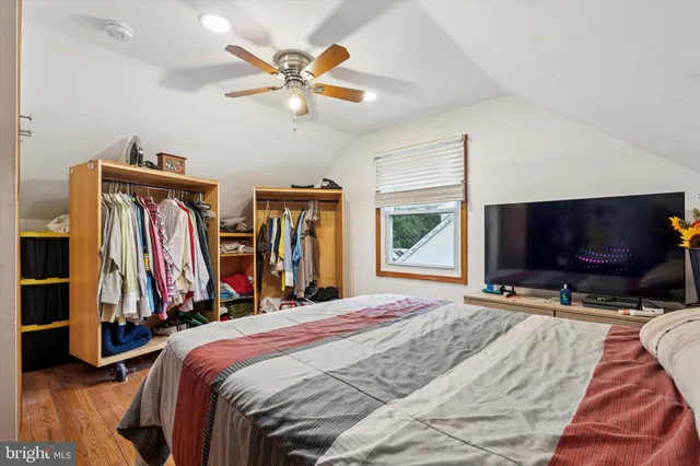 a bedroom with a bed and a flat tv screen on the dresser