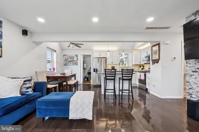 a living room with furniture and a dining table with kitchen view
