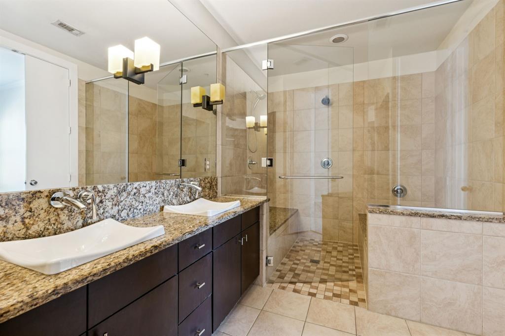 2950 McKinney Avenue, Unit 424 Dallas, TX 75204 - Photo 14 of 25 a bathroom with a granite countertop sink a large mirror and a shower