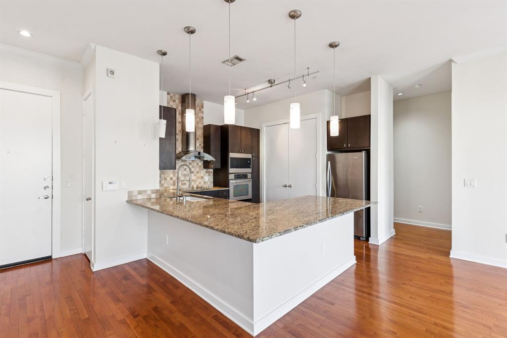 2950 McKinney Avenue, Unit 424 Dallas, TX 75204 - Photo 2 of 25 a kitchen with stainless steel appliances granite countertop a refrigerator and a sink