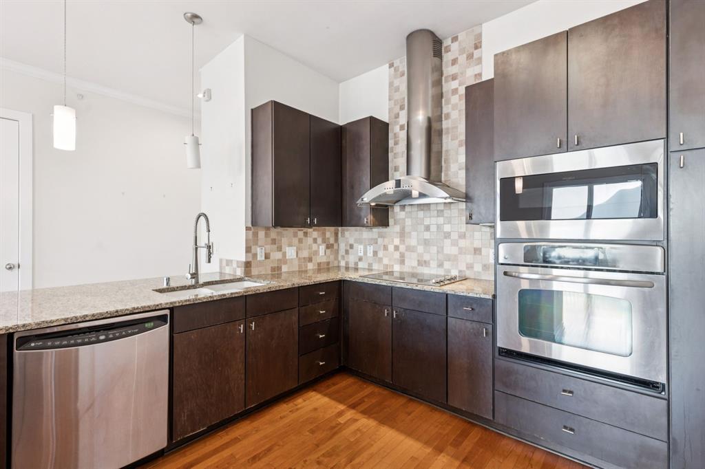 2950 McKinney Avenue, Unit 424 Dallas, TX 75204 - Photo 3 of 25 a kitchen with stainless steel appliances kitchen island granite countertop a refrigerator and a sink