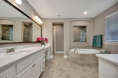 a spacious bathroom with a granite countertop tub sink and mirror