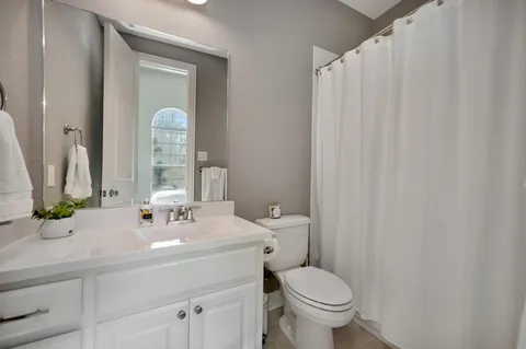 a bathroom with a toilet a sink and a mirror