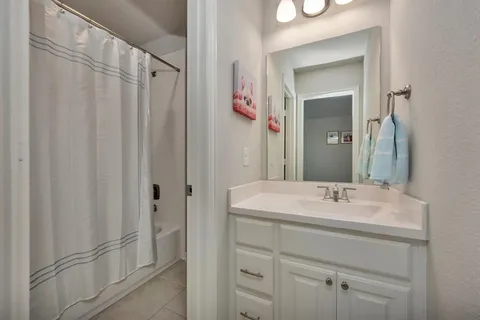 a bathroom with a sink a mirror a vanity and a shower
