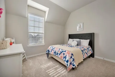 a bed sitting in a bedroom next to a window