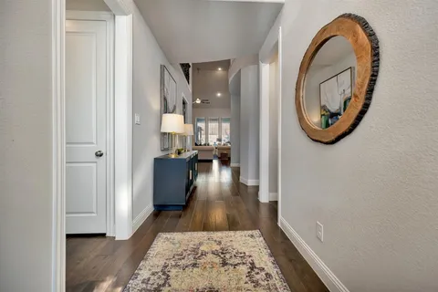 a view of a hallway with wooden floor and a bathroom view