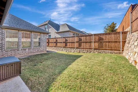a view of a backyard with wooden fence