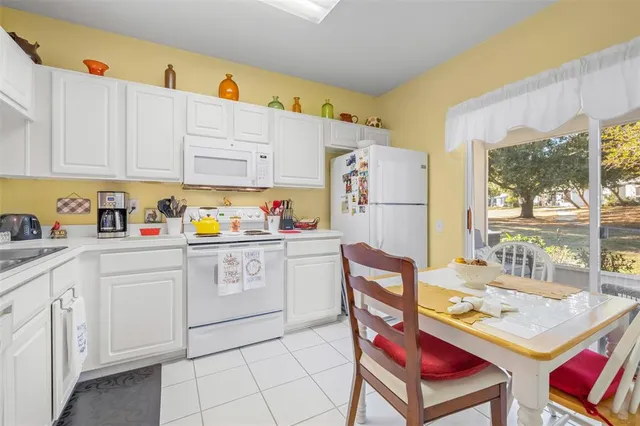 a kitchen with stainless steel appliances granite countertop a refrigerator a sink dishwasher and white cabinets with wooden floor